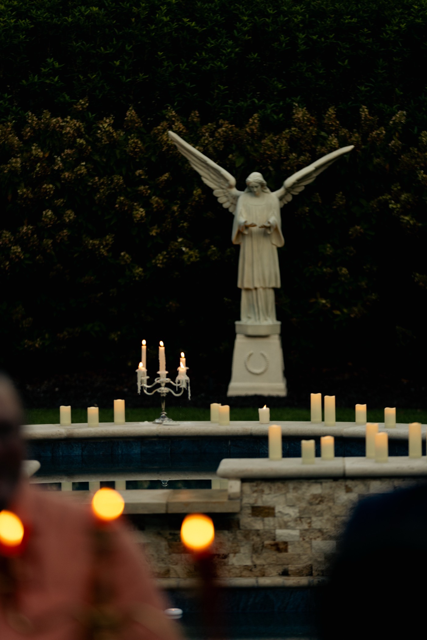 The Angel statue over the garden with candles at night