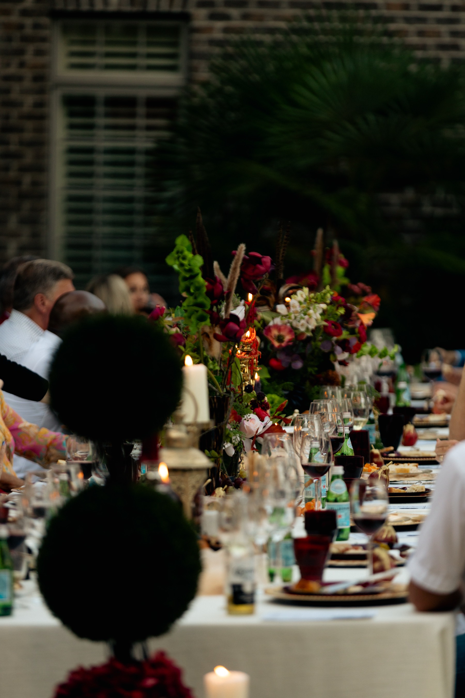 The long table deep into the evening, florals and candlelight down its length
