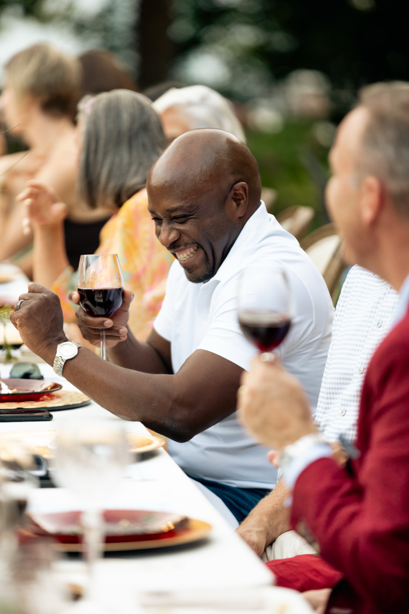 A guest laughing with a glass of wine